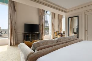 a hotel room with couches and a flat screen tv at Shangri-La Paris in Paris