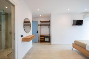 ein Schlafzimmer mit Bett und ein Badezimmer mit Spiegel in der Unterkunft Hotel ENAD in Ksamil