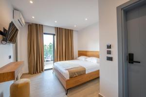 ein Hotelzimmer mit einem Bett und einem Fenster in der Unterkunft Hotel ENAD in Ksamil