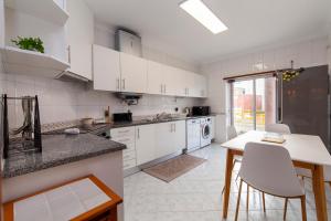 eine Küche mit weißen Schränken und einem Tisch und Stühlen in der Unterkunft B102 - Sol Sol Lagos Apartment in Lagos