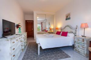 Schlafzimmer mit einem Bett, einem TV und einer Kommode in der Unterkunft B102 - Sol Sol Lagos Apartment in Lagos