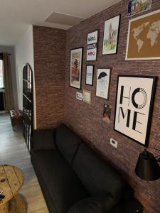 a living room with a couch against a brick wall at Loft Opale in Calais +17 photos
