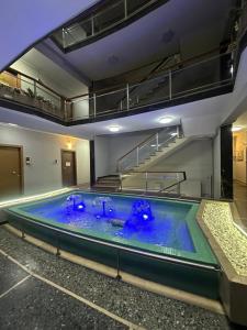 ein großes Schwimmbecken mit blauem Wasser in einem Gebäude in der Unterkunft Premium Seafront Suite in Thessaloniki