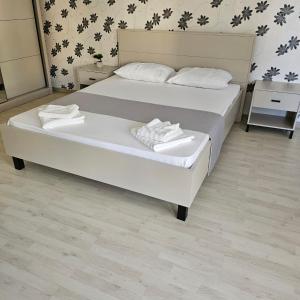 ein Schlafzimmer mit einem Bett mit zwei weißen Handtüchern darauf in der Unterkunft Lovely apartment in Craiova