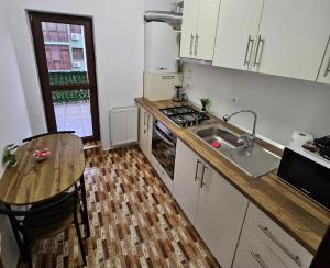 a kitchen with a table and a sink and a counter at Lovely apartment in Craiova