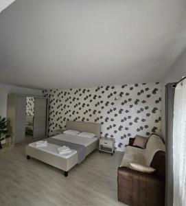ein Schlafzimmer mit einem Bett und einer Couch in der Unterkunft Lovely apartment in Craiova