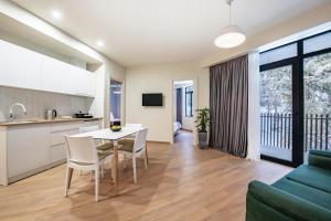 Una cocina y una sala de estar con mesa y sillas. en Dialog Kokhta, en Bakuriani