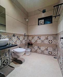 un baño con inodoro y lavabo en The Boho Peach Villa, en Mount Abu