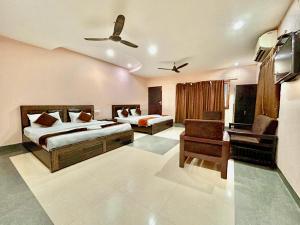 瑞诗凯诗Buddha Retreat in Rishikesh, India的有两张床和一把椅子的酒店房间