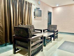 瑞诗凯诗Buddha Retreat in Rishikesh, India的一间医院间,配有桌椅和电视