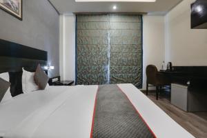 Habitación de hotel con cama y piano en Collection O Cambridge, en Dhankot