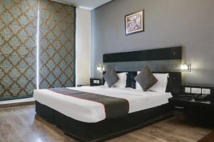 Un dormitorio con una cama grande y una ventana grande en Collection O Cambridge, en Dhankot 17 fotos más