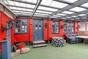 灵克宾Charming Townhouse By The Harbour的一间红色的房间，蓝色的门，还有一张桌子。