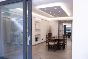 comedor con mesa y puerta de cristal en Coco Noir Luxury Villa, en Trecastagni