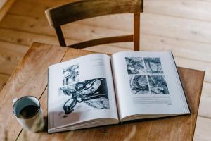 an open book on a table with a cup of coffee at Tannherz in Kleines Wiesental
