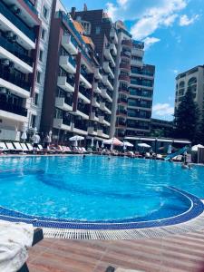 a large swimming pool with some chairs and some buildings at ADMIRAL PLASA studiyo-25C in Sunny Beach