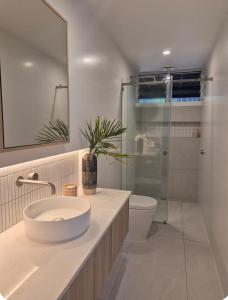 ein Badezimmer mit Waschbecken, Toilette und Dusche in der Unterkunft Luxury Coastal Private Villa in Peregian Beach