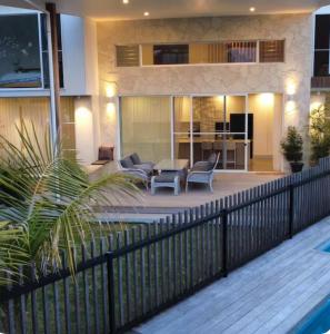 ein Haus mit einer Terrasse mit einem Zaun in der Unterkunft Luxury Coastal Private Villa in Peregian Beach