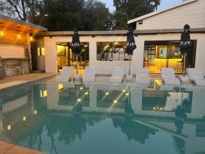 ein Pool mit Stühlen und Lichtern vor einem Gebäude in der Unterkunft Little Mykonos in Johannesburg