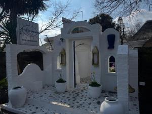 ein weißes Haus mit weißen Vasen davor in der Unterkunft Little Mykonos in Johannesburg