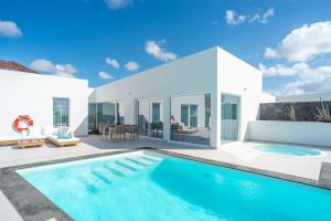 a villa with a swimming pool and a patio at Ereza Hoopoe Villas in Playa Blanca