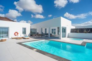 a villa with a swimming pool and a patio at Ereza Hoopoe Villas in Playa Blanca