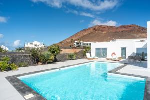 a swimming pool in a villa with a mountain in the background at Ereza Hoopoe Villas in Playa Blanca +70 photos