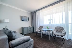 a living room with a couch and a table at Hotel Wodnik Twój Hotel z widokiem na morze in Ustronie Morskie
