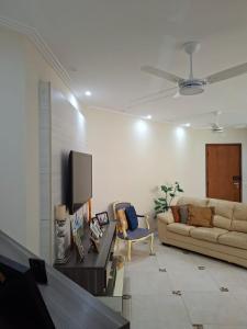 ein Wohnzimmer mit Sofa und Fernseher in der Unterkunft Apartamento Enseada in Guarujá