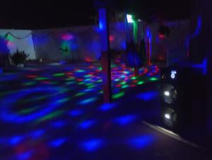 a dark street with blue and green lights at Hostel Mamitchesca in Canoa Quebrada