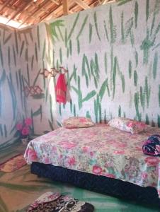 a bedroom with a bed with a painting on the wall at Hostel Mamitchesca in Canoa Quebrada