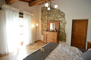 a bedroom with a stone wall and a large bed at Historic Farmhouse In The Tuscan Hills in Caprese Michelangelo