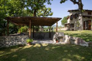 a backyard with a wooden pergola and a house at Historic Farmhouse In The Tuscan Hills in Caprese Michelangelo +5 photos