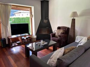 ein Wohnzimmer mit Couch und Kamin in der Unterkunft Casa Riu in Riu de Cerdanya