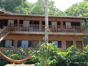 a building with a balcony and a tree at Pousada Mar Azul in Trindade