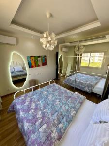 een grote slaapkamer met 2 bedden en een kroonluchter bij Cozy crystal lounge in Sheikh Zayed +10 foto's