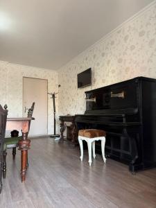 uma sala de estar com um piano e uma mesa em Bright & Spacious Family House em Tbilisi