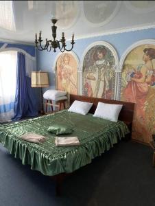 Апартаменти в парку في أومان: غرفة نوم بسرير اخضر مع لوحة على الحائط