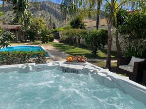 a pool with a hot tub in a yard at Casa Lucale in Palermo