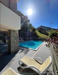 einen Pool mit einem Stuhl neben einem Haus in der Unterkunft Seven Keys - Ecrin Savoyard in Valmeinier