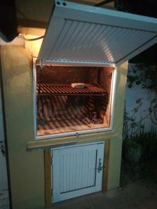 a grill with hot dogs on top of it at Casita funcional en Claromeco in Balneario Claromecó