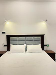 une chambre avec un grand lit blanc avec deux oreillers dans l'établissement Harmon Weligama, à Weligama