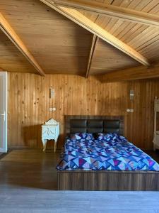 uma cama num quarto com tecto em madeira em Bright & Spacious Family House em Tbilisi mais 34 fotografias