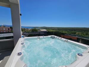 a jacuzzi tub on a balcony with a view at Villa Madison, Spacious Sea View Apartments Near Zadar with heated pool in Posedarje