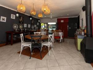 a dining room with a wooden table and chairs at Woodpecker's Guest House in Hazyview +5 photos