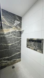 bagno con parete in marmo bianco e nero di Casa ampla próxima ao centro a Dourados Altre 21 foto