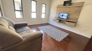 un soggiorno con divano e TV a schermo piatto di Casa ampla próxima ao centro a Dourados