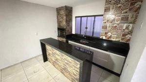 una cucina con bancone nero e finestra di Casa ampla próxima ao centro a Dourados
