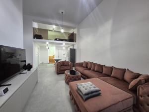 a living room with a couch and a tv at Infinity Loft Residence in Târgu Jiu