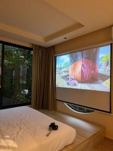 une chambre avec une télévision grand écran et une caméra sur le lit dans l'établissement Hẹ Stay, à Hue